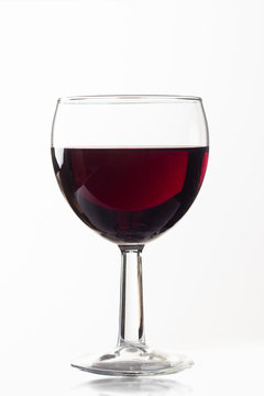 Side view of a glass glass of red wine on a white isolated background. Concept of wine preparation and tasting
