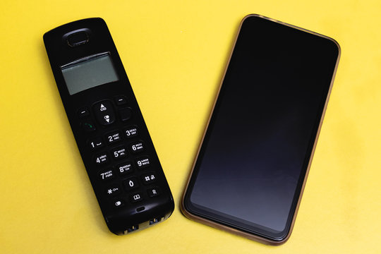 Old push-button telephone and modern smartphone close up
