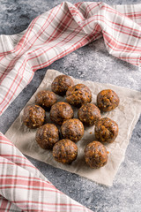 Fruit and nut energy balls on parchment paper, flat lay.