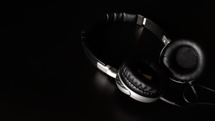 Fototapeta na wymiar Black headphones isolated on a black background,close up