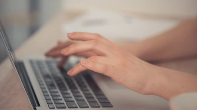 Fast typing on the laptop keyboard. The bright background.