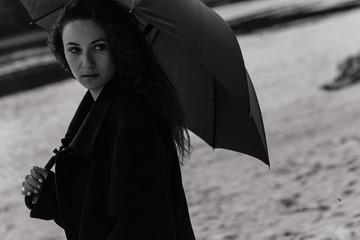 Woman in the coat with umbrella in her hands