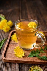 Herbal drink for liver detox, dandelion root tea in a glass cup decorated with fresh flowers