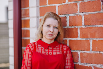 beautiful woman in red blouse. wrinkles on woman's face. blonde in a red blouse. a good looking mom