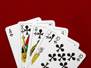 Playing cards. Royal flush on red velvet background