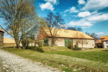 Fototapeta na wymiar A very old barn in a yard in a sunny idyllic mood