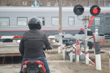 Railway crossing. Motorcyclist at a railway crossing. View from the car.
