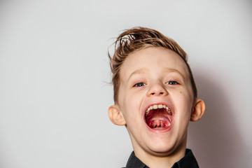 Funny guy in a black shirt laughs with open mouth on a white background