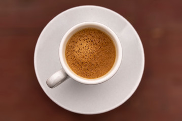 Cup of coffee for breakfast on braun background.