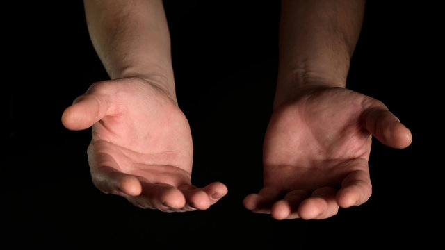 Human male palms isolated on black background. Close up.