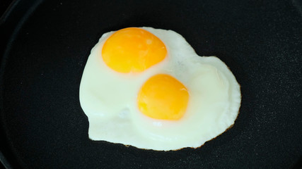 Cooking Fried eggs in pan on stove. Close up.