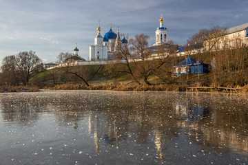 A beautiful white church stands on a lake is reflected in the ice