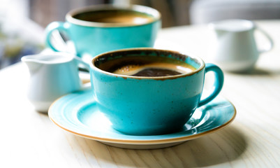 .two green cups with coffee on the table