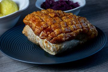 Pork roast with crackling on a black plate  ready to eat