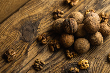 Walnut scattered on the wooden vintage table. Walnuts is a healthy vegetarian protein nutritious food. Walnut on rustic old wood.