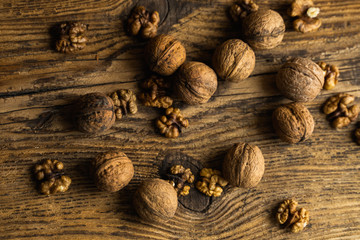 Walnut scattered on the wooden vintage table. Walnuts is a healthy vegetarian protein nutritious food. Walnut on rustic old wood.