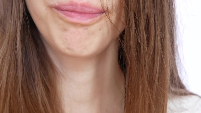 Juicy lips of a young beautiful woman drinking the beer from a glass close up