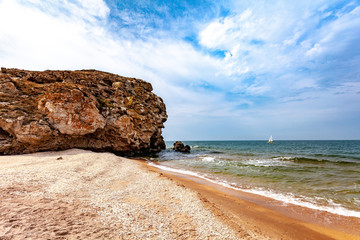 Panoramic view of the coast of the Sea of ​​Azov. Sandy beach, rock. White ship on the turquoise water of the sea. Copy space.