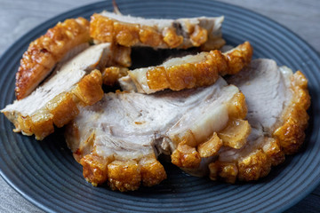 Pork roast with crackling on a black plate  ready to eat