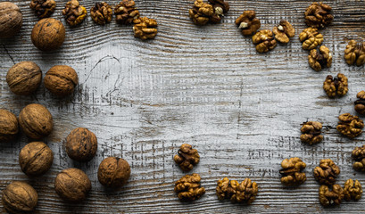 Walnut scattered on the wooden vintage table. Walnuts is a healthy vegetarian protein nutritious food. Walnut on rustic old wood. Copy space.