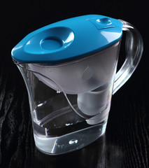 Water filter jug at black background
