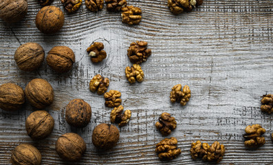 Walnut scattered on the wooden vintage table. Walnuts is a healthy vegetarian protein nutritious food. Walnut on rustic old wood. Copy space.