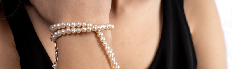 woman with pearl diamond necklace in hand