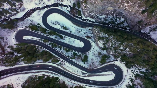 Aerial drone view of a serpentine in rocky mountain forest, Bicaz gorge with winding road in winter season,Cheile Bicazului, Romania