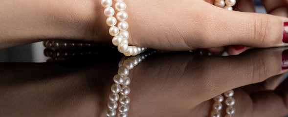 woman with pearl diamond necklace in hand
