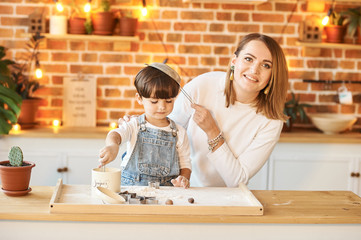 Fototapeta premium young beautiful family having fun and cooking in the sunny kitchen