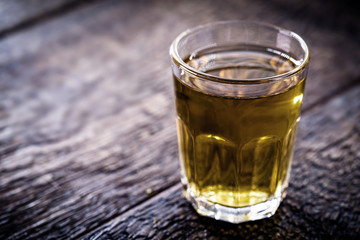 small glass cup for alcoholic drink. Rustic wood background.