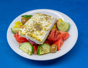 Greek salad plate with original feta cheese, olives, green pepper slices, tomatoes, onions and cucumber slices