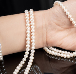 woman with pearl diamond necklace in hand