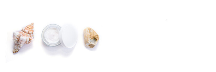 Banner with opened facial cream and sea shell and stone on the isolated white background. Place for text. Nature skin care.