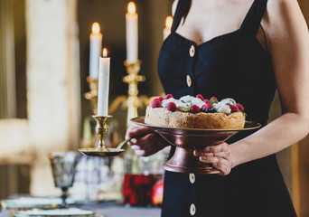 woman with a cake near a table with candles