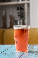 Glass with strawberry mojito cocktail with lemon and mint, cold refreshing drink or beverage with ice on gray background. Overhead view, copy space. Advertising for cafe menu.