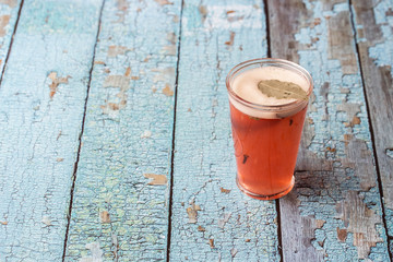 Glass with strawberry mojito cocktail with lemon and mint, cold refreshing drink or beverage with ice on gray background. Overhead view, copy space. Advertising for cafe menu.