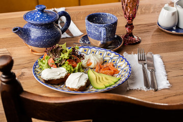 Poached eggs with salmon and avocado on sourdough toast isolated on wooden background. Homemade food. Tasty breakfast. Selective focus. Top view.