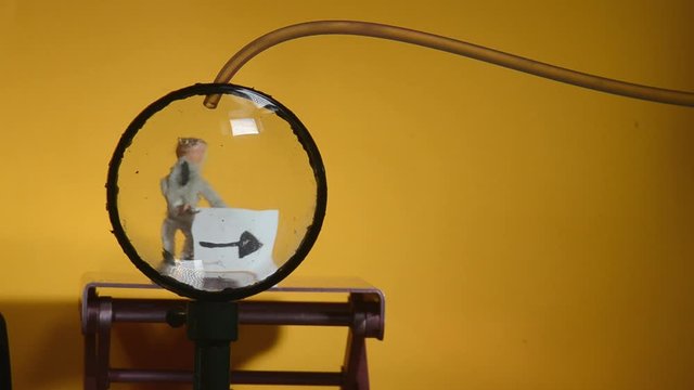 A classic experiment: A little figurine is seen trough two convex watch glasses. The space between the glasses is filled with a liquid, the glasses become a lens and the figurine turns upside down.
