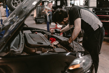 Car auto repair service. Oil change. Auto service. Mechanic man works. Car repair shop. Automobile maintenance. Vehicle part replacement. Repairman inspects engine in car. Car overhaul. Car lifted