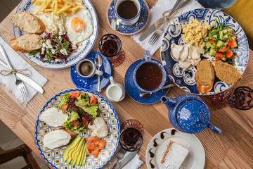 Poached eggs with salmon and avocado on sourdough toast isolated on wooden background. Homemade food. Top view. eating and leisure concept - group of people having dinner at table with food
