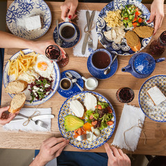 Poached eggs with salmon and avocado on sourdough toast isolated on wooden background. Homemade food. Top view. eating and leisure concept - group of people having dinner at table with food