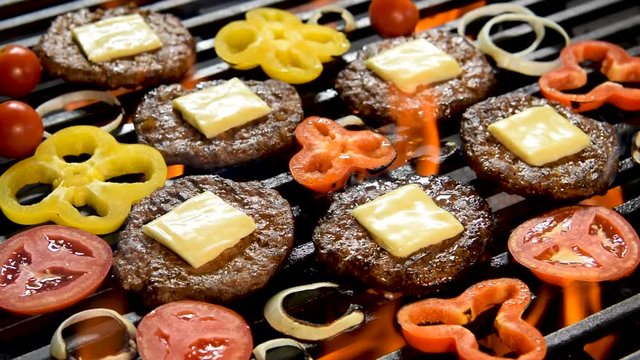 Grilled meat/burger with vegetable on the flaming grill .