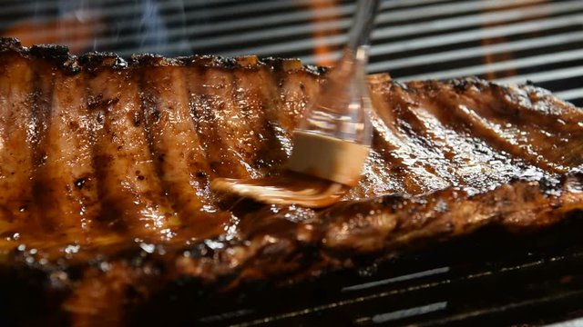 Grilled pork ribs on the flaming grill .