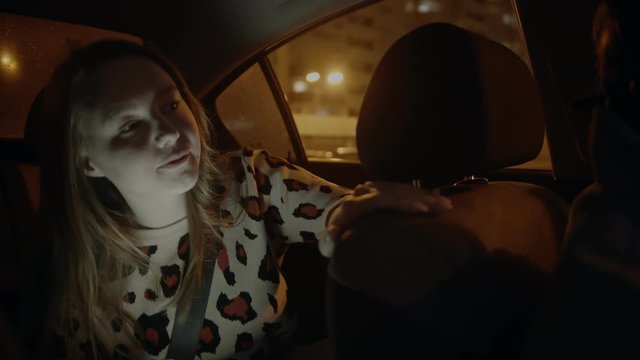 Young Smiling Woman In The Backseat Of A Car - Talking With Driver