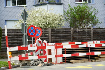 horizontal barrier planks in red and white and two traffic signs do not stop on a complex civil...
