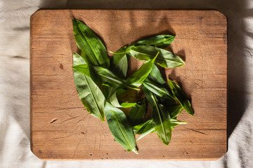 wild garlic or ramson on wooden cutting board, top view