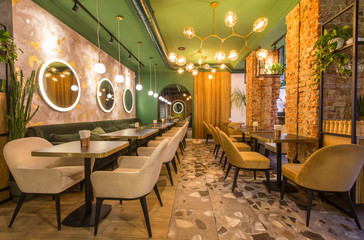 Modern restaurant interior with tables and sofas, light green walls