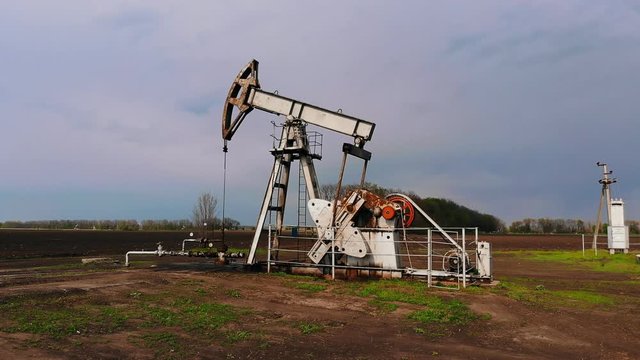 Aerial photography - Working oil pumps against sun / Oil pump jack. oil rocking oil field