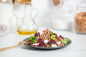 boiled buckwheat with radish and beetroot  on a plate, vegetarian dish